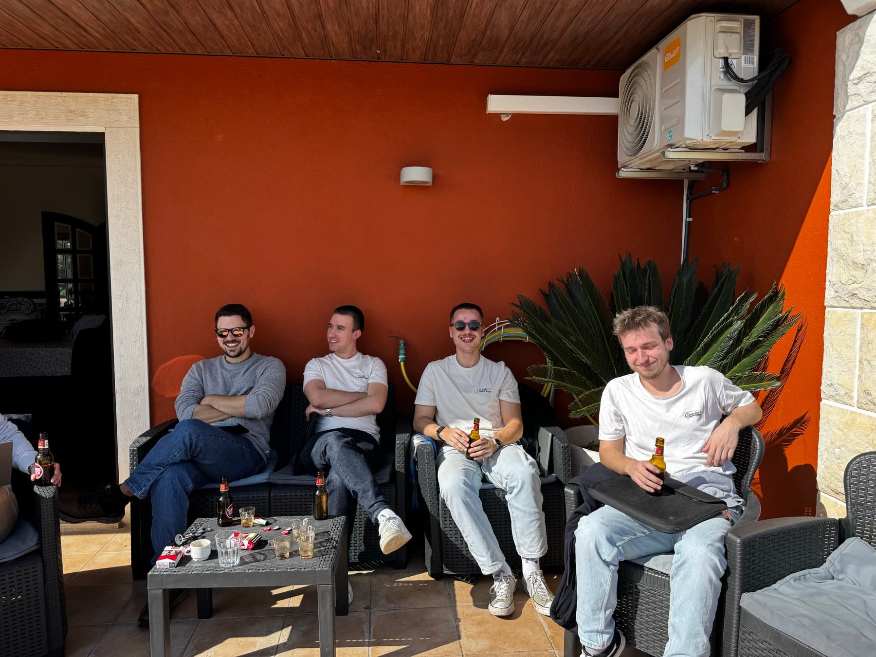 four of the team on a terrace, beers in hand
