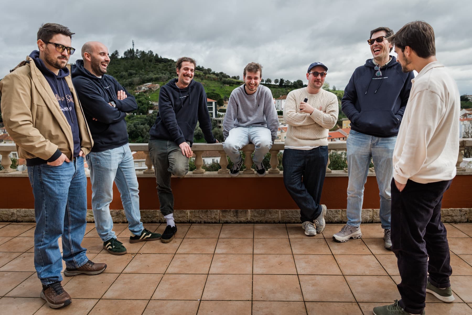 seven of the team on a rooftop, hills behind